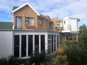 View of back of house with sun room and balconies.